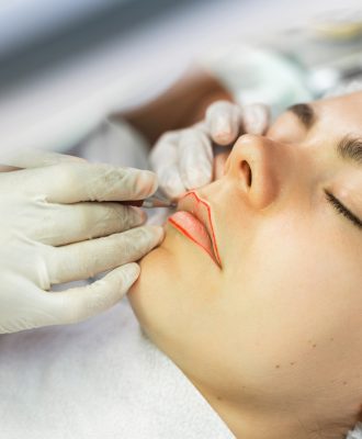 Permanent makeup artist and her client during lip blushing procedure