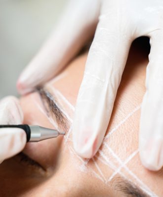 Woman during professional eyebrow mapping procedure